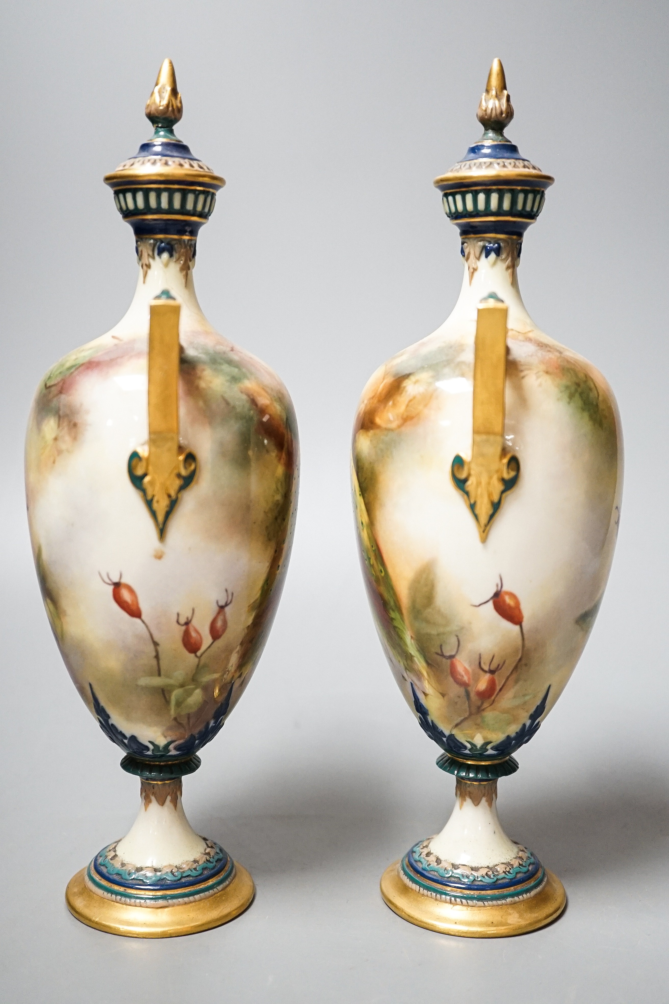 A pair of Royal Worcester Hadley ware Peacock vases and covers 24cm